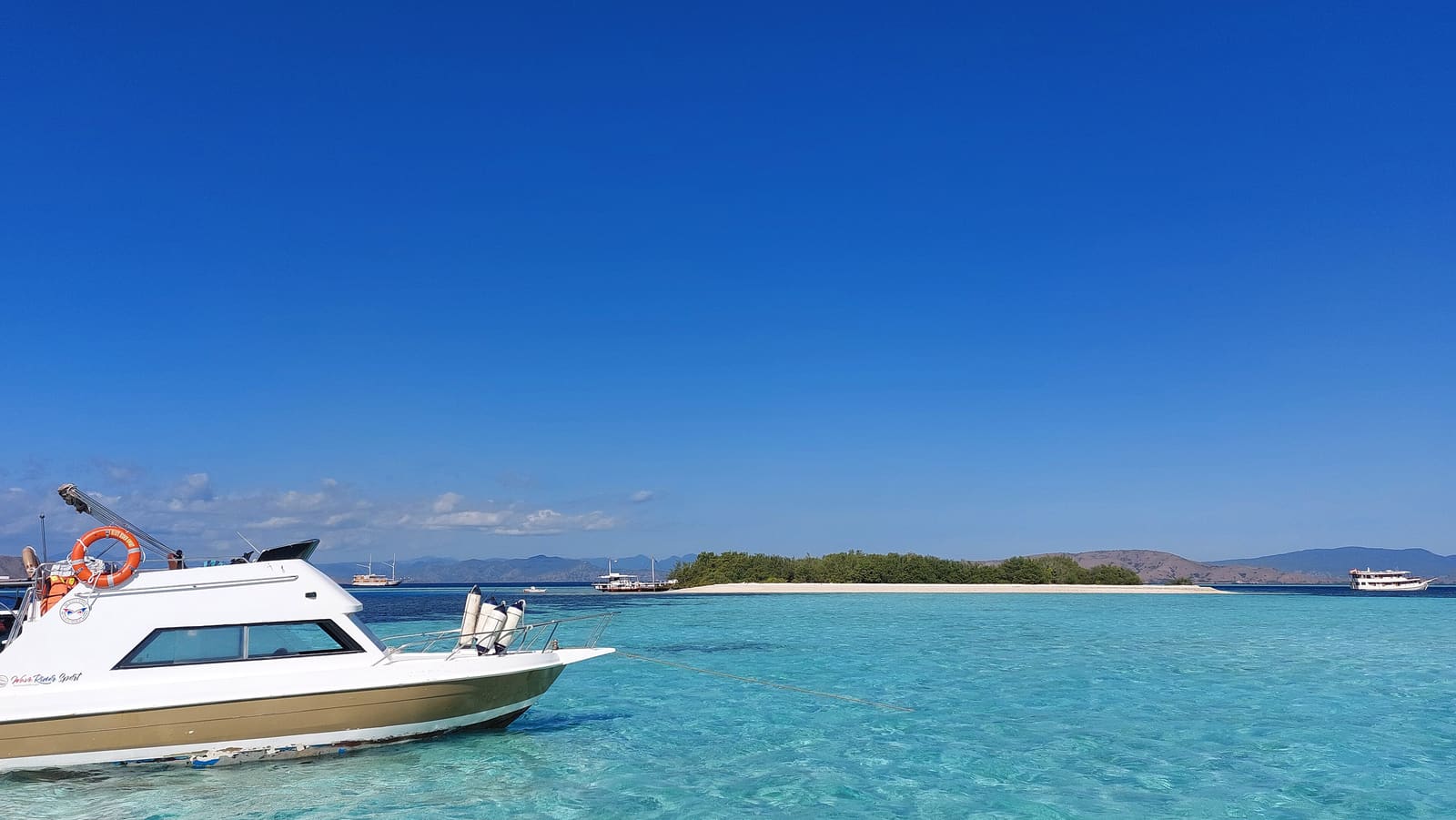 A speedboat beside the pale sandbar of Taka Makassar in turquoise water
