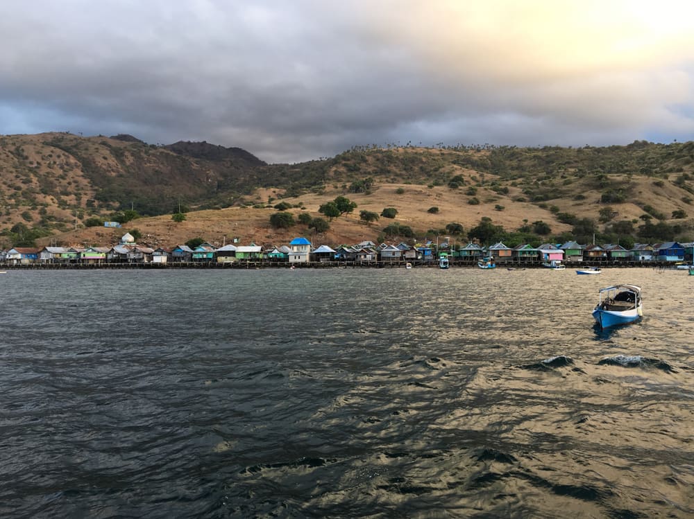 Stilt houses of a fishing village beneath dry hills in Komodo National Park