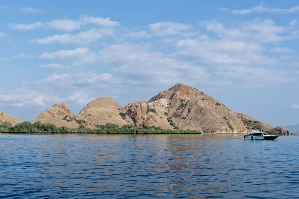 The rocky peaks of Siaba Besar Island above calm blue water
